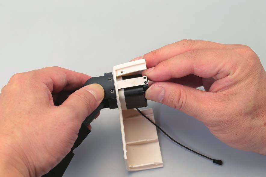 your finger over the circular hole in the arm to prevent the cable coming loose.