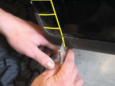 For trucks without factory flares ONLY: Wrapping tape measure up from underside of fender,