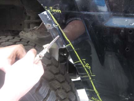 Using a hammer, bend the tabs of sheet metal into fender well as shown.