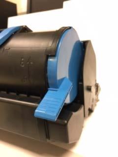 With the print cartridge sitting on the flat surface look into the small window in the access panel. Move the blue lock lever to the down / unlocked position.