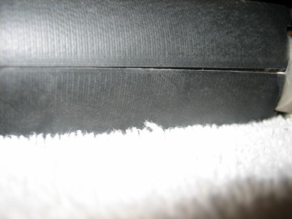 If you have a nice tight fit at the bottom, but there is a gap at the top, part of the grip is still hitting the frame.