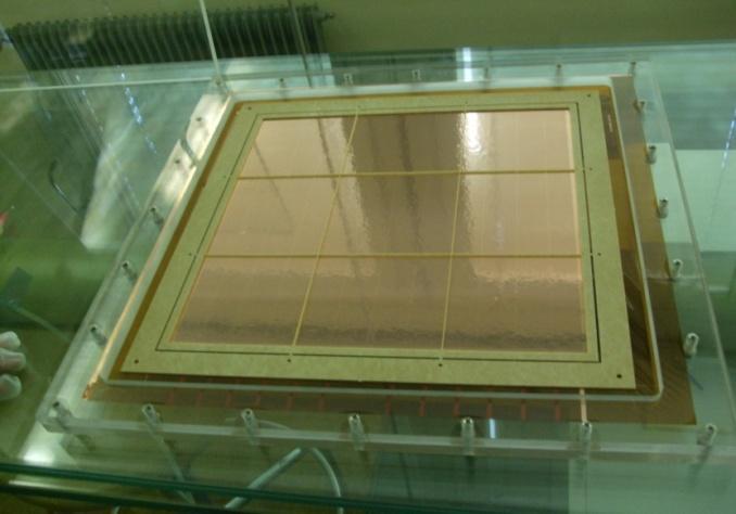 Place one side of the frame with the glue close to the active area touching the kapton, hold in the center of that side with one hand and with the