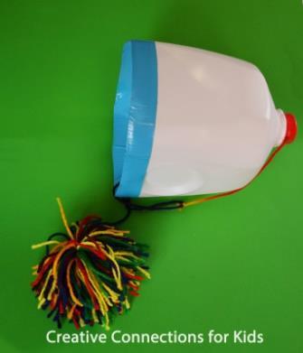 Milk Jug Toss A yarn pom-pom is attached to a milk jug with yarn or string.