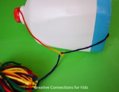Materials: gallon milk jug yarn yarn pom-pom scissors colorful duct tape optional Procedure: Cut the bottom off of the