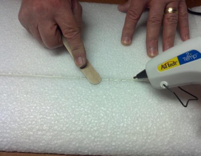 25. Put hot glue in the slot, and then insert the spar. Fill in any gaps above the spar with hot glue, and smooth the surface. 26. Use snips to cut off any excess spar sticking out on the sides. 27.