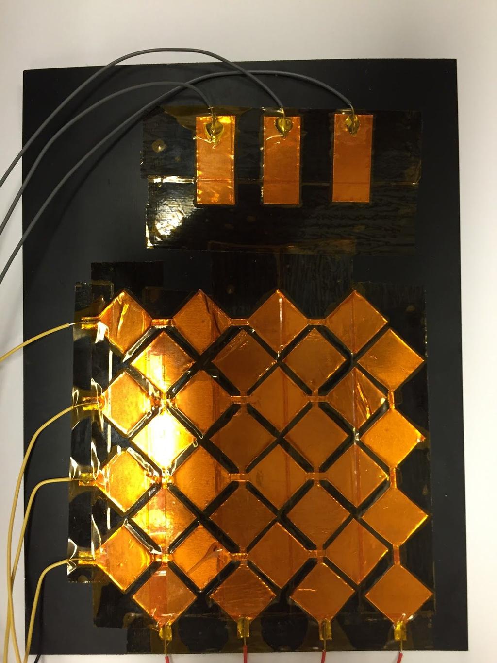template. To isolate the capacitive plate from the user, the grid and pads were covered in Kapton Tape, a thin, transparent, and electrically insulating material.