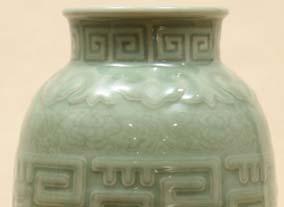in blue with the pattern outlined in a deeper blue glaze. Celadon vase with molded design.