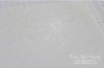 side with Serene Snowflakes in Crumb Cake ink. Stamp several snowflake images by applying Frost White Shimmer Paint onto the stamp with a Sponge Dauber and stamping the image onto the card stock.