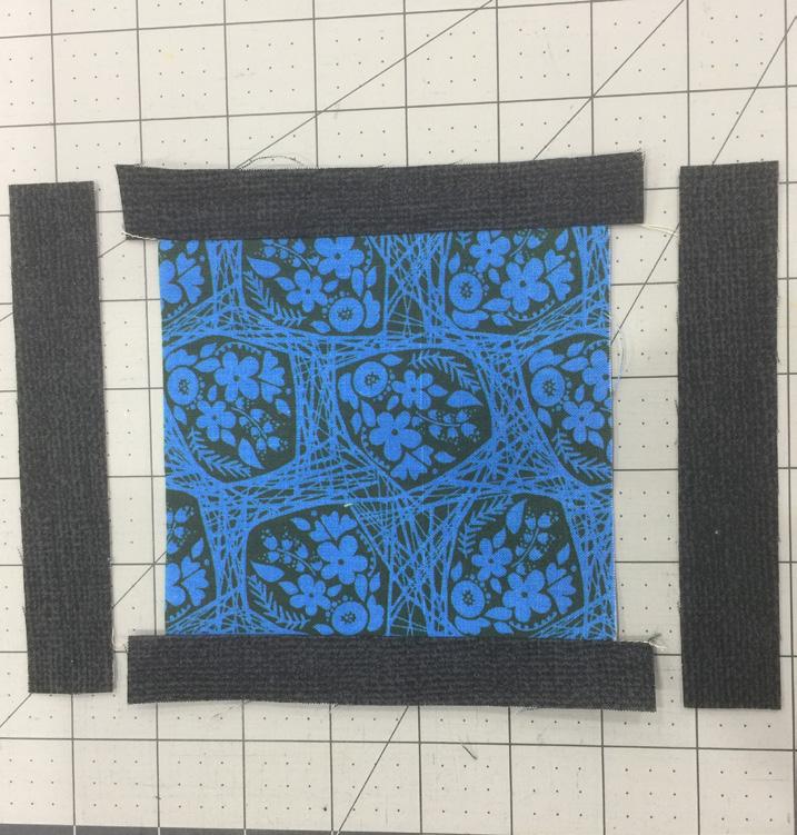 Take the (2) 5-3/4 x 1 pieces of fabric A and place them right sides together on the remaining edges of the 5 square fabric B.