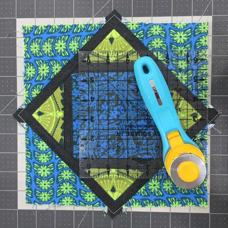 Repeat with the remaining 3 triangles of fabric D with the other edges of the in-progress block and then pin in place.