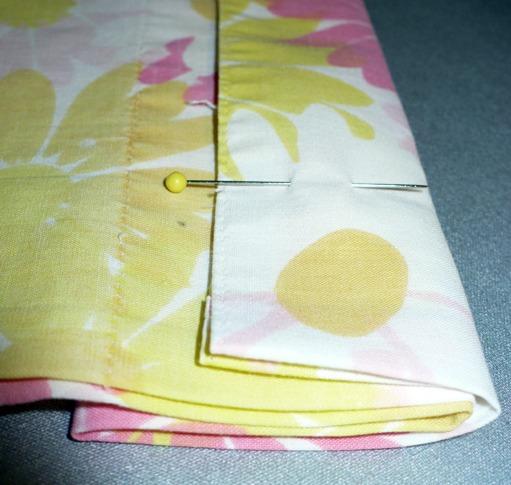 At the top of the case, which was previously ironed flat (except for the ½ inch folded in to the wrong side) fold both sides over together 3 ¾ inches. Pin this in place and iron the crease.