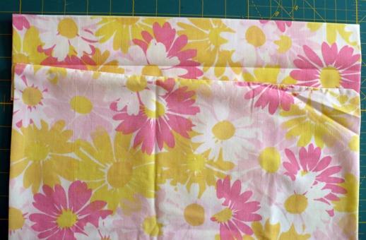 10) On your rotary cutting mat or table, turn the case over, with the seam you just sewed facing down. Fold the original bottom seamed edge of the pillowcase up towards the crease from step 7.