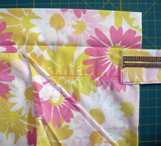 13) Fold the angled pieces back up, returning to the 1 inch below the fold in the waist band. Pin in place. Stitch ¼ inch from the edge.