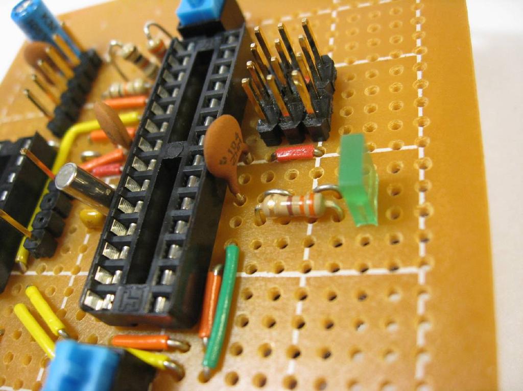 The long yellow jumper with the 90 bend in it will have to be custom formed to fit in place. Place an LED, a 330 Ω resistor (orange-orangebrown), (4) jumper wires, and a 0.