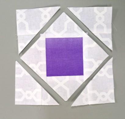 Sew (2) of the white strips for your size pineapple ruler x wof and (1) center square strip size x wof (violet) strip into a strip set as shown. Press seams to the white (example) fabric.