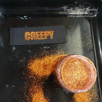 Sprinkle orange glitter from the Black & Orange Stampin Glitter over the sticky creepy and shake off excess. (6g) Cut out creepy in a rectangle.