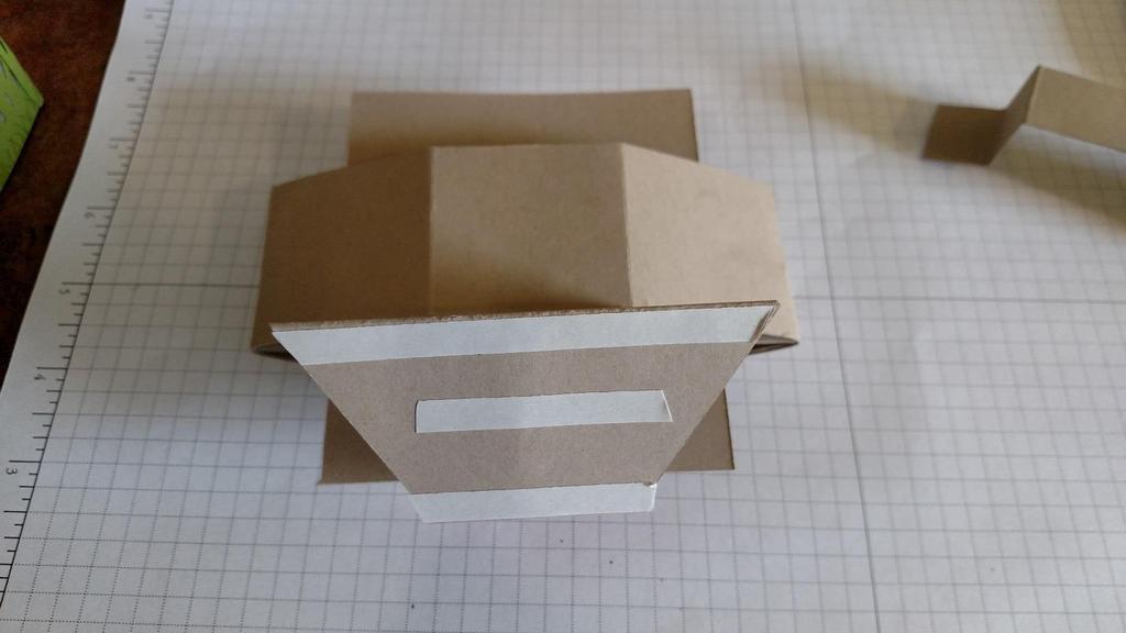 8. On box, fold the hexagon pieces in and burnish the folds. Bring them back out and apply adhesive to the inside of the flap of one of the sides. Slip sky piece into box.