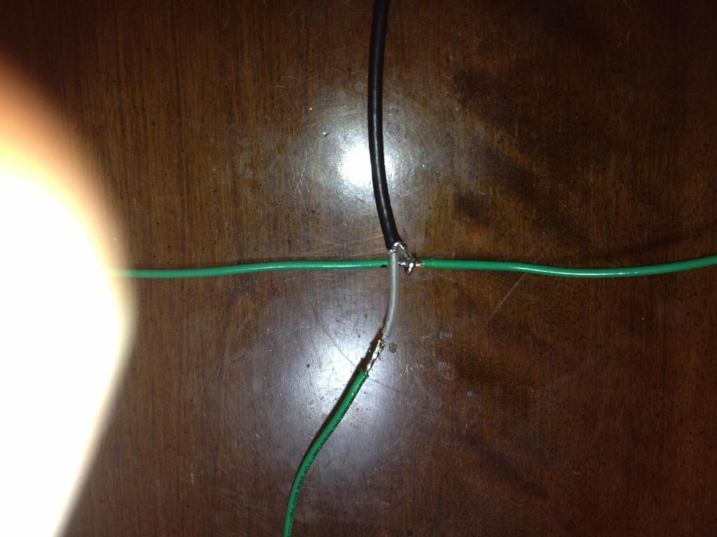 The dipole construction suggests connecting the antenna elements (wire) to the coax by using a piece of perf board. I directly soldered the coax to the ¼ wave length pieces of wire as shown below.