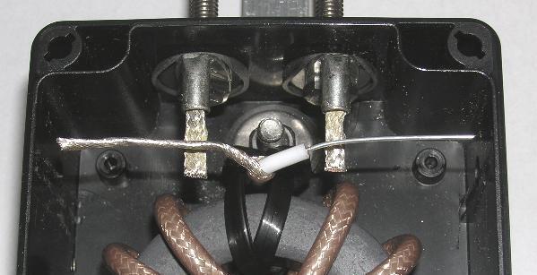 Keeping the center cut of the coax in the center of the case, cut off the ends of the coax such that they are nearly
