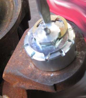 Loosen the lower ball joint nut until 3-5 threads are still on the nut, this will prevent the knuckle from falling off.