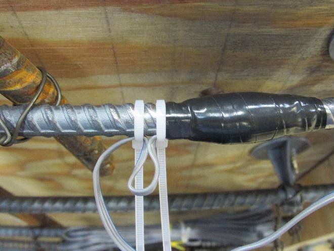 4.7.3. Using a second zip tie, secure the far end of the looped wire to the bar a short distance from the zip tie applied in Article 4.7.1. Do not completely tighten this second zip tie completely.