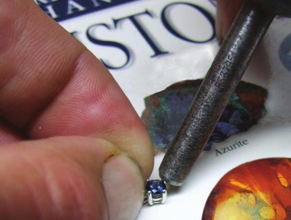 Being careful not to touch the gemstone, place the sharp beveled edge of the lifter under the prong.