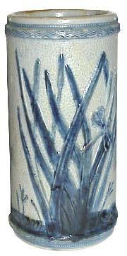 VASE Tall and cylindrical jar measuring 8 1/2 tall and 4 1/2 wide. This is the only piece that features the trademark head.
