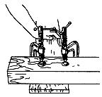 (Illus. 2). Be sure to have the thumbscrews up! (If they are down, you may hit them while sawing.) c. Use a hammer or block of wood to tap the 2 x 4 gently until it lines up along your pencil line. d. Now tighten the clamp enough to hold the 2 x 4 in place.