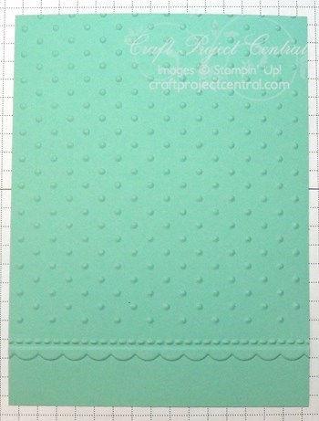 Insert the card stock into the Perfect Polka Dots embossing folder, lining up the bottom edge of the folder along the top of the embossed scallop border, and run it through