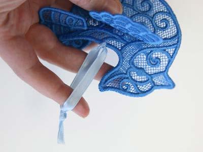 Cut a 7" length of ribbon or string, and lace it through the back of the bird