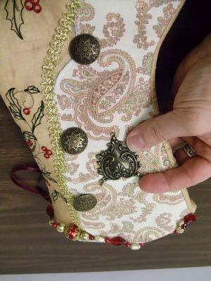 Add any buttons and remaining pendants. Hand sew them in place. Add beaded garland to the top edge of the stocking.