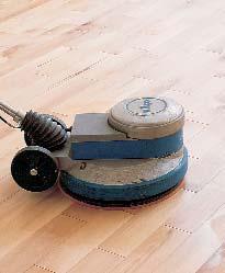 The oil is applied with a roller or metal blade and distributed in a uniform layer on the sanded floor.