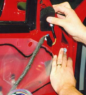 Guide the wire harness down to and through the small opening in the door.