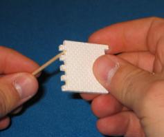 Place a small amount of glue on a scrap of plastic card or other