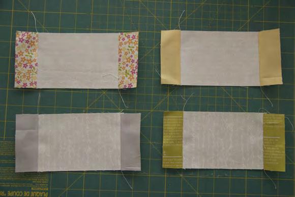 7. Using the FE pieces you cut for your center square, add these as a border. Add the pieces measuring 1.5 x 5.5 to each top and bottom. Press. Then add the pieces measuring 1.5 x 7.
