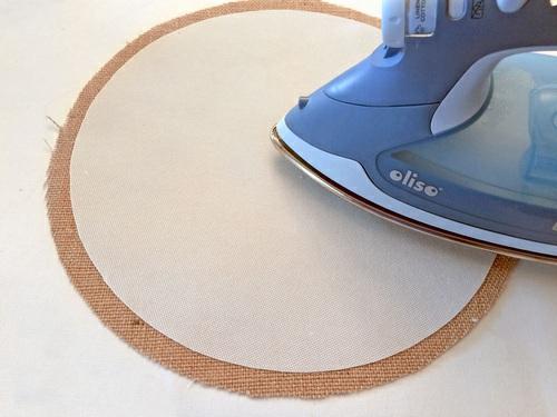 Following manufacturer's instructions, first fuse the base interfacing in place. It should be centered on the exterior circle so there is ½" of burlap showing all around the interfacing.
