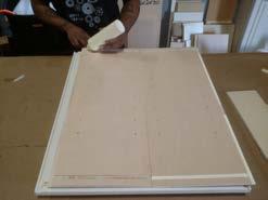 Lay the cabinet side panels down on a flat surface and run a bead of glue through the side daado channels, as