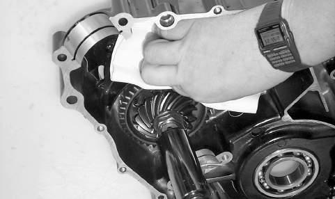 To remove the assembly, remove the nut securing the secondary drive gear and secondary driven gear; then from the inside of the crankcase using a rubber