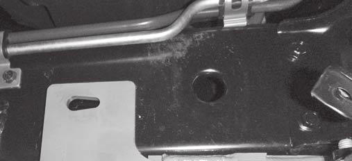 Insert a 1/2" x 1-1/2" cap screw with handle into the access hole on the inside of the driver-side frame at the location shown.