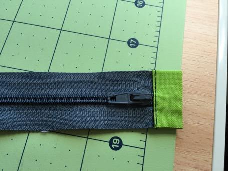Line up the unfolded side of zipper tab and sew a 1/2 inch seam.