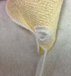 (Photo D) Carefully push the left edge over drawing the buttonette toward the eyelet.