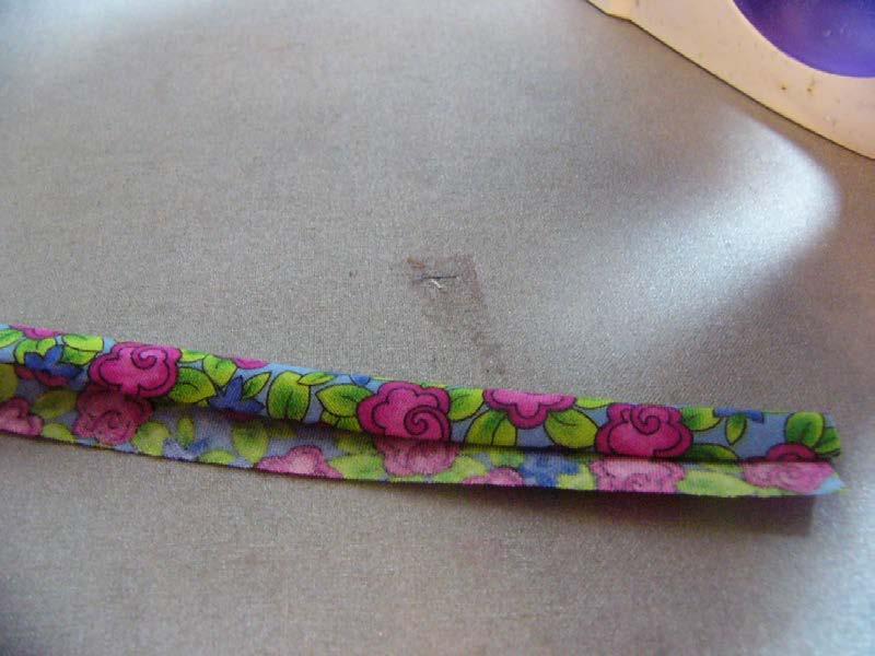 Then on one edge, fold the edge of the bias strip into the center ¼ and press. It will look something like this. 12.