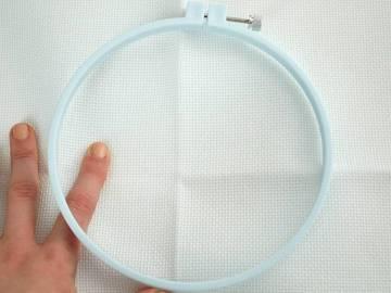 Place the solid round piece of the hoop behind the fabric with the