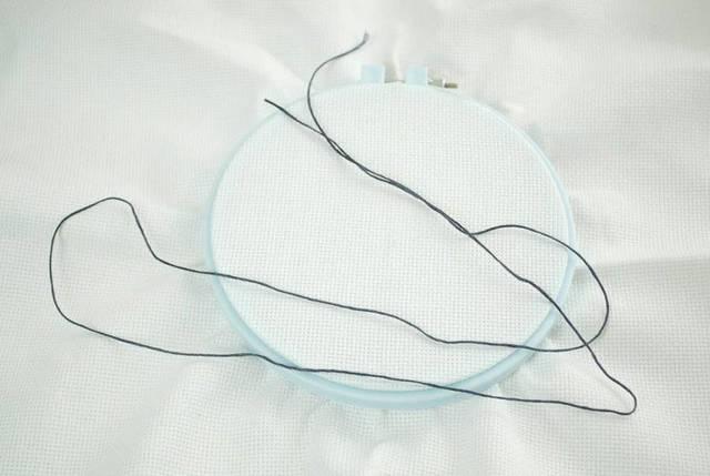 will make your first stitch. Pull the fabric taught in the hoop and tighten the adjustment screw as tightly as you can.