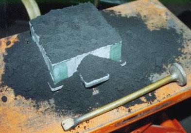 Sand Casting 3. The sand is tipped in the box and rammed down. The ramming tool is shown in front.