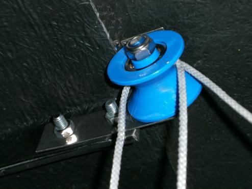 Thread the rope through the pulleys as displayed in the picture and attach each end of the rope to front and rear of the sliding aperture lid, at the centre, as shown.