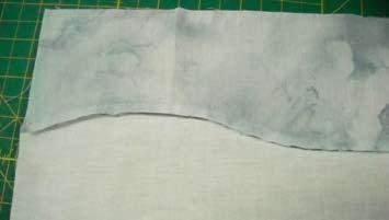 If necessary, press the background piece, then line it up on top of your full-size pattern, aligning the fence line on
