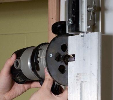 See Photo 11a Photo 11a Position the centering clamp at the top of the router fixture onto the door panel