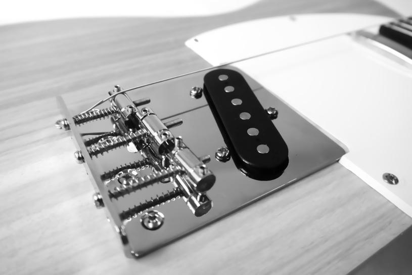 3.9 Strings, neck relief, string height and pickups Stringing the guitar The strings are threaded from the bridge towards the neck over the corresponding