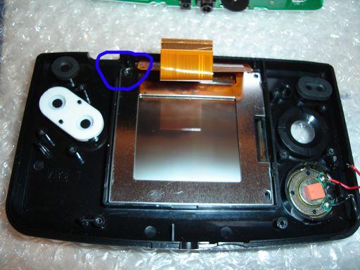 The next step takes the utmost care as you can possibly damage your NGPC LCD. At the spot circled insert your flat head screwdriver under the LCD about 1/8.